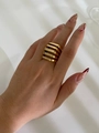 Macro detail of a wide five-layer cutout geometric gold ring on a female hand - Gold / No. 8