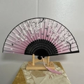 Pink cherry blossom folding fan with black frame and pink tassel on wood stand - Jade Tree and Orchid (Black)
