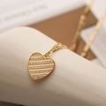 Macro shot of 18K gold plated heart pendant necklace with white stripes and crystals - White Striped Shell Style Heart