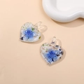 Macro view of heart-shaped glass pendants with blue flower patterns and golden glitter - Blue (Type A)