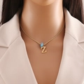 Detail of gold necklace with letter Z pendant and blue evil eye bead on model - Letter Z (N1339)