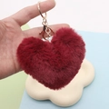 Furry red heart-shaped plush keychain with a golden metal ring held in hand - Wine Red / Gold Split Ring