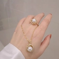 Detailansicht der vergoldeten Schmuckgarnitur mit Muschelperlen und funkelnden Kristallen - Kleeblatt Muschelperlen Ring / Gold