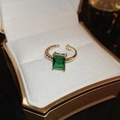 Close-up of rectangular emerald cut green stone ring in a premium gold jewelry box - Emerald Green (Open/Small)