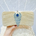Elegant gold sequin clutch bag with peacock jeweled clasp held by a model for a gala dinner - Gold
