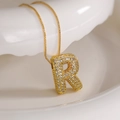 Golden R letter pendant necklace with cubic zirconia paving on a clean white surface - Letter R (Box Chain)