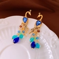 Detail van pauwoorbellen met blauwe edelstenen en kleurrijke kralenkwastjes op keramiek - 32# Zilveren pin - Goud Blauw Pauw Kwast