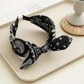 Detail of vintage paisley print headband with black and white knot design on tray - Navy Blue