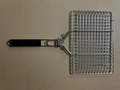 Detail of a square stainless steel grill pan with holes and a black handle for BBQ - 32x21cm Fish Grill Net