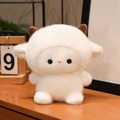Plush white lamb stuffed toy with soft curly fur and brown horns on a wooden desk - Lamb / 15CM