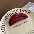 Handmade burgundy acetate hair claw clip with gold lettering on a ceramic plate - Faux Oval