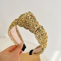 Close-up of a wide knotted headband with gold square studs and pink lining detail - Gold Wide Knot Headband