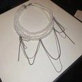 Detailansicht der mehrlagigen Perlenkette mit eleganten silbernen Kettenquasten - Dreilagiger Perlen Metall Quasten Stil