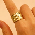 Close-up of golden wide band ring with irregular hammered texture on woman's finger - Honeycomb Texture (0137)