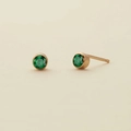 Macro view of round emerald stud earrings in gold bezel setting for women - May Green - Gold
