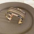 Detail of gold multilayer enamel bracelet with leopard print pattern on ceramic plate - Multi-layer Open Stackable Set / Gold Leopard Black