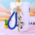 Detail of crystal-encrusted gold snake keychain with a blue woven rope and charm - Royal Blue Lucky Rope + Blue Snake