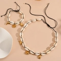 Detail of seashell jewelry set with golden dolphin, fish, and turtle metal charms - Black Rope Fish Set