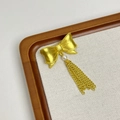 Detail einer Vintage-Gold-Bogenbrosche mit Perlen und metallischen Kettchenfransen - Gold