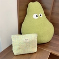 Détail d'une trousse à maquillage en tweed coloré avec étiquette sur bois foncé - Vert