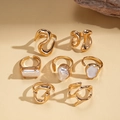 Dettaglio del set di sette anelli dorati irregolari con perle e design in metallo liquido - Oro