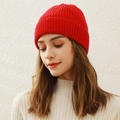 Women's warm red knitted beanie hat in cozy winter style worn by model on white background - Red