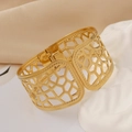 Macro detail of a wide gold-plated bangle with geometric honeycomb cutout design - Gold Wide Geometric Hollow (1163-2)