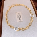 Dettaglio di collana a maglie ovali dorate con smalto bianco su fondo di lino rustico - Collana (Oro-Bianco)