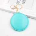 Detail of mint green portable folding mirror with golden metal keychain on a white frame - Green