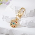 Detail of bohemian gold metal evil eye keychain with colorful rhinestones on stone background - Gold Minimal Rhinestone Blue & White Eye