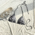 Flat lay of a leopard print bikini top with halter neck ties and starfish accessories - Black White Grey Leopard