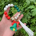 Close-up of Christmas silicone beaded bracelet with Santa charm, bell, and white tassel - Style 1 (Green Bell Santa Claus)