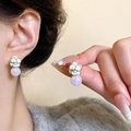 Detail of camellia flower pearl earrings with iridescent lavender luster on model - White Camellia Iridescent Pearl Studs