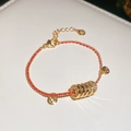 Close-up of gold-plated woven red string bracelet with five sparkling coin charms - Gold-Red (Gold Plated)