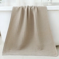 Absorbent waffle weave cotton bath towel in beige draped on a white bathtub edge - 70*140cm / Light Gray