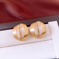 Détail des boucles d'oreilles dorées en forme de C avec zircons dans un écrin à bijoux - Or Brossé (Tige en Argent) / Doré