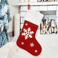 Détail d'une chaussette de Noël en tricot rouge avec flocons blancs et revers en peluche - Style Flocon de Neige