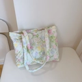 Detailopname van gebloemde gewatteerde katoenen shopper met chique Frans tekstlabel - Olieverf groen roze bloemen