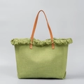 Green woven canvas tote bag with decorative fringe and brown leather handles on grey background - Light Green