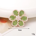 Vue détaillée d'une broche tournesol de 4cm avec strass verts et perles blanches - D1405 Fleur de Perle Verte