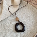 Détail du collier pendentif en résine et bois avec perles ambrées et marron sur lin - Style Géométrique Carré (HN9947)