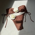 Flat lay of brown bikini set featuring 3D white rose details and side tie bottoms - Coffee