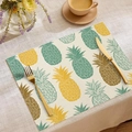 Detalle de mantel individual de lino con estampado de piña y cubiertos dorados elegantes - Piña Tropical