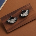 Macro detail of vintage black fan-shaped earrings with floral patterns on a wood base - Silver Fan H2271