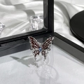 Macro shot of silver butterfly ring with red enamel and blue gemstone on white satin - Silver Dark Red Enamel Blue Gem Butterfly Style (16)