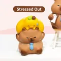 Brown capybara resin figurine wearing a blue tie with a small yellow pear on its head - Under Pressure Capybara (3087) / Ornament Series