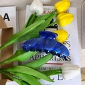 Detail of dark blue star-patterned hair claw clip with tulips and vintage book background - Starry Blue