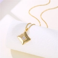 Close-up of golden square pendant necklace with clear zircon stone on white background - Gold