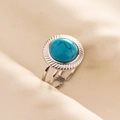 Detailed shot of round turquoise ring with silver cutout band on beige silk fabric - Silver Turquoise Style / Silver Dark Blue (J566-S-DB)