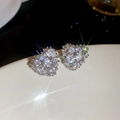 Macro shot of silver heart stud earrings with sparkling cubic zirconia on white surface - 18K Gold Plated / Silver